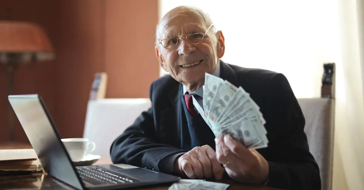 Happy senior businessman showing cash at his desk with a laptop, indoors.